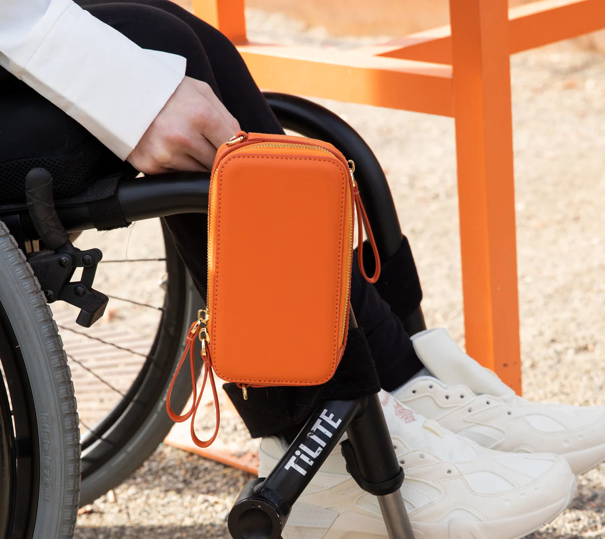 Orange bag show at side of wheelchair